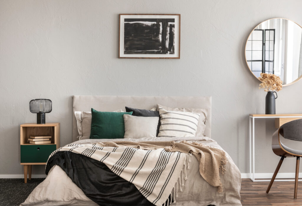 Picture of a bedroom with painting and mirror on wall