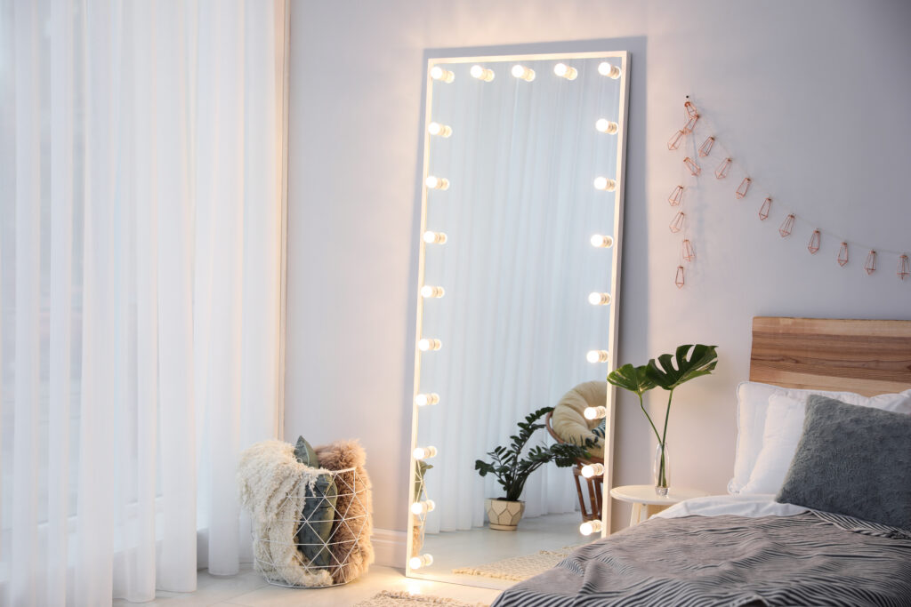 Picture of a room with a large lit up floor length mirror